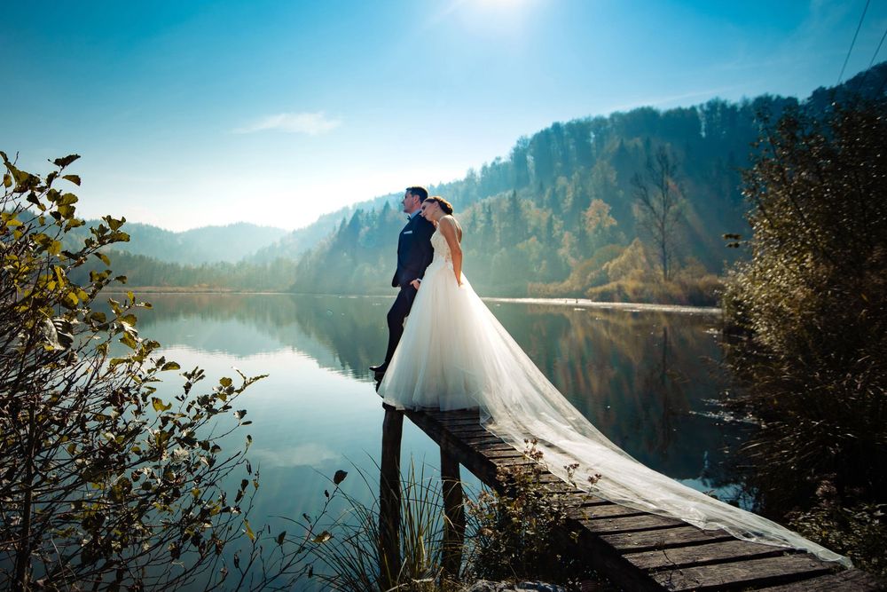 Scenic wedding photos captured against mountain lake backdrop during golden hour.
