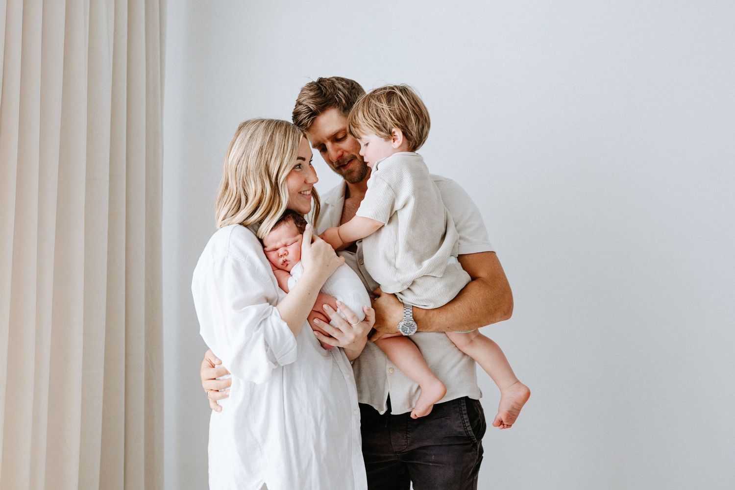 A romantic photoshoot series in white shows intimate moments between a couple against a light backdrop.