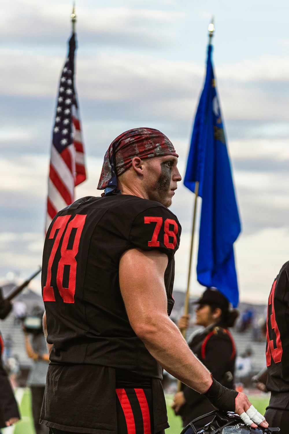 Football player in the middle of the American Flag and Nevada State Flag