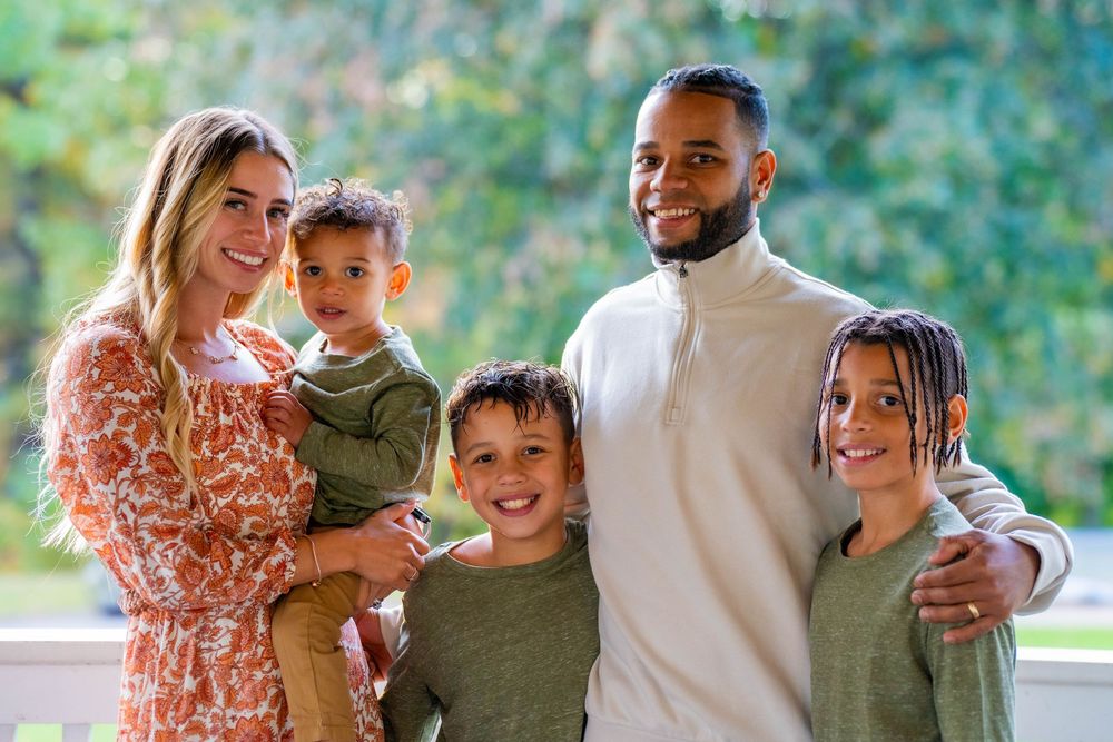 Family enjoying autumn outdoor photoshoot in coordinated outfits.