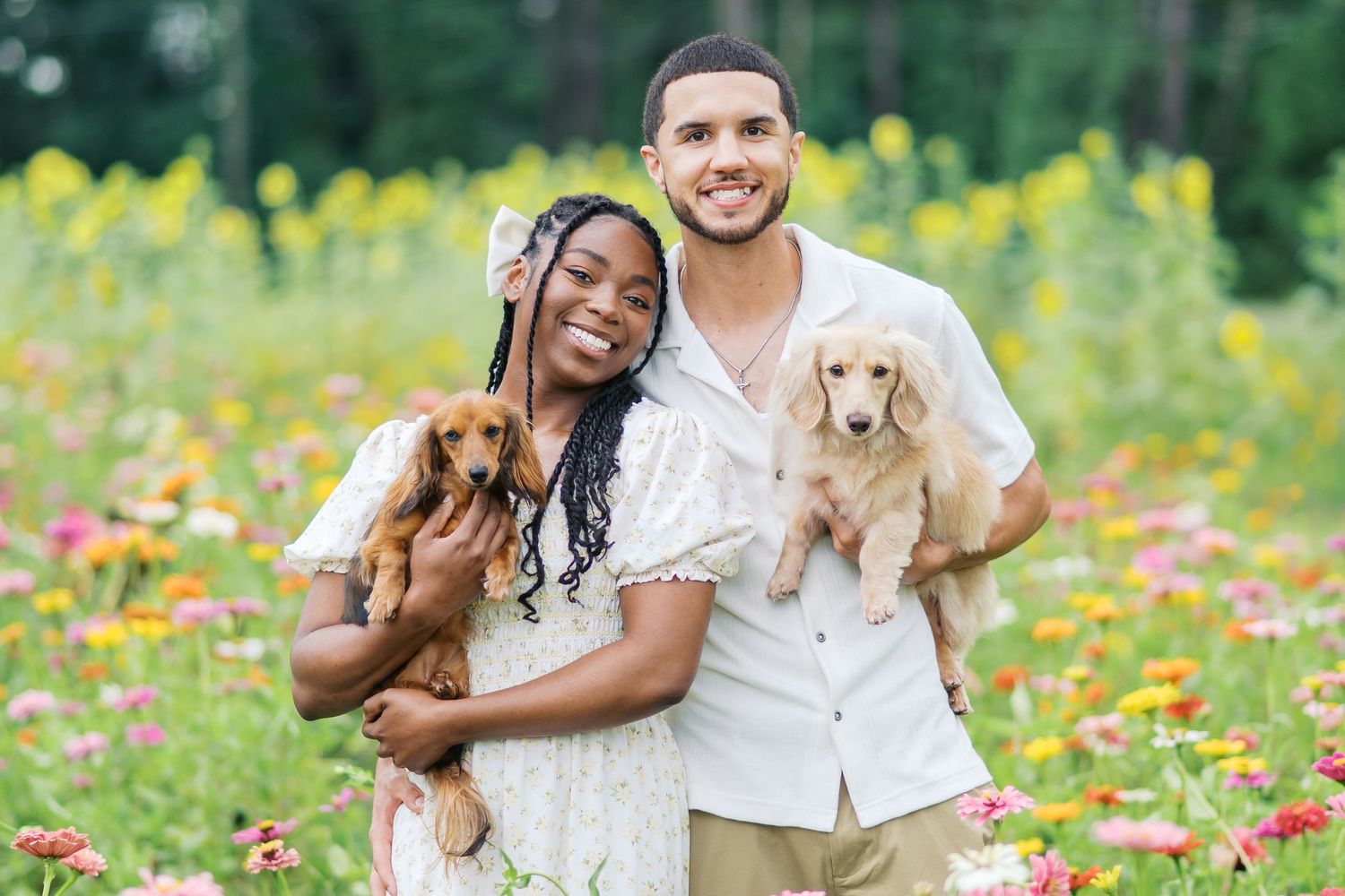 Happy couple shares joyful moments together while standing in a blooming wildflower meadow on a sunny day.