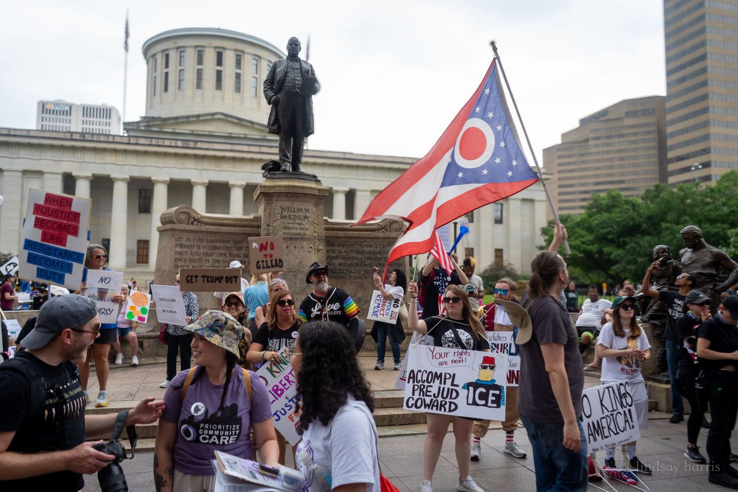 People gather for a protest at the Ohio State Capitol with signs and flags during a peaceful demonstration.