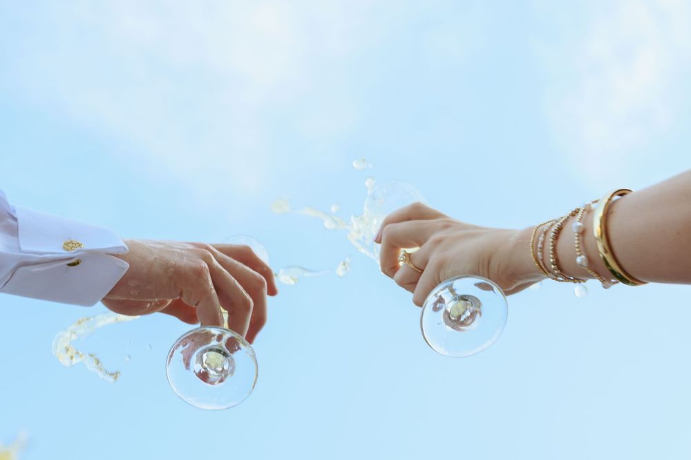 A series of hands holding sparklers against a bright blue sky creates a dreamy and whimsical scene.