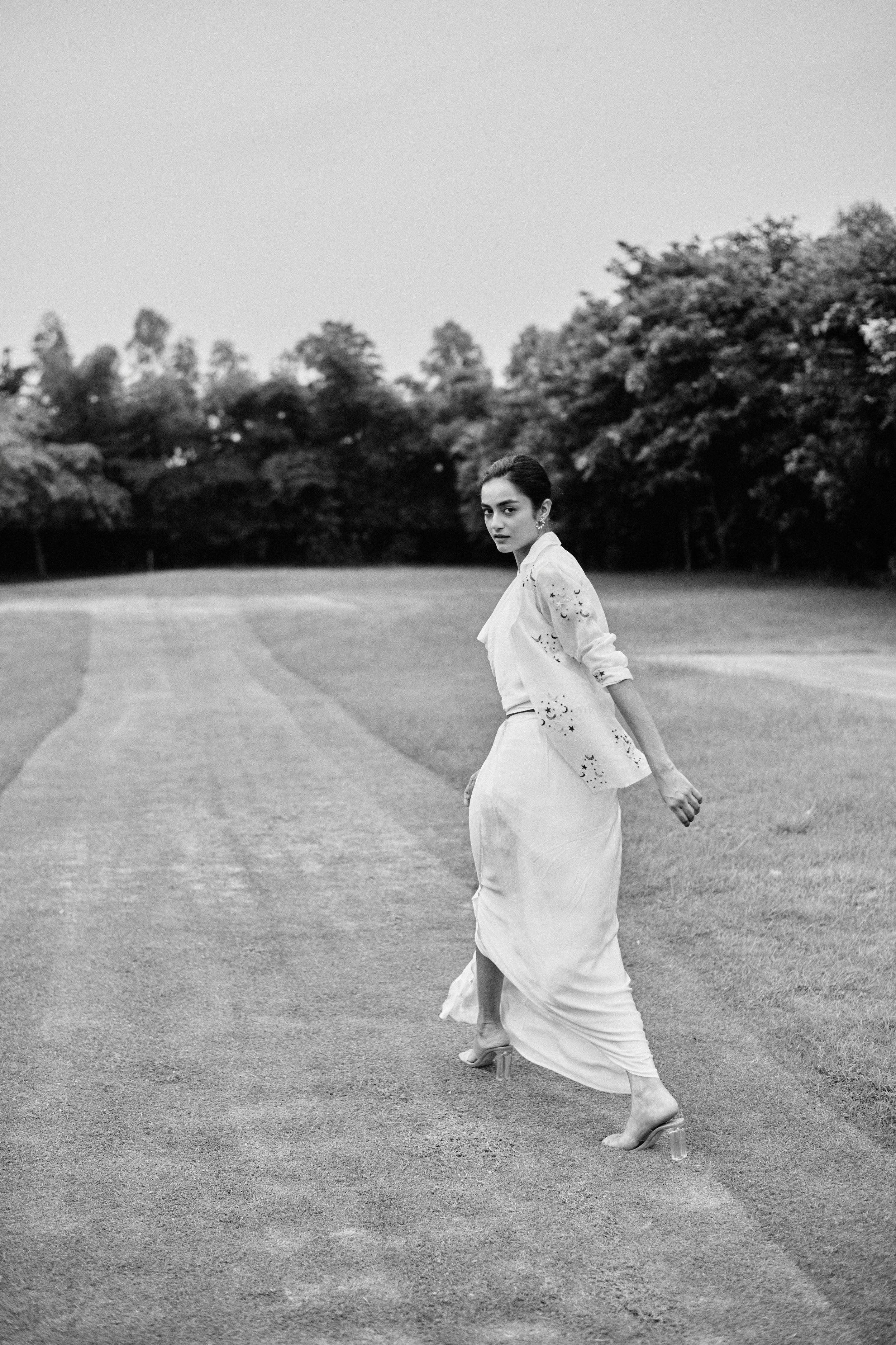 Black and white editorial shot of a model with refined styling, evoking classic Vogue aesthetics.