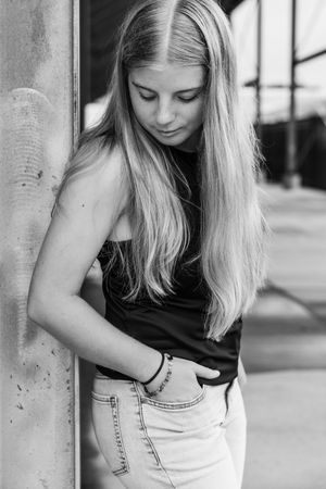 Black and white photo series showing a person with blonde hair leaning against a wall in various candid poses.