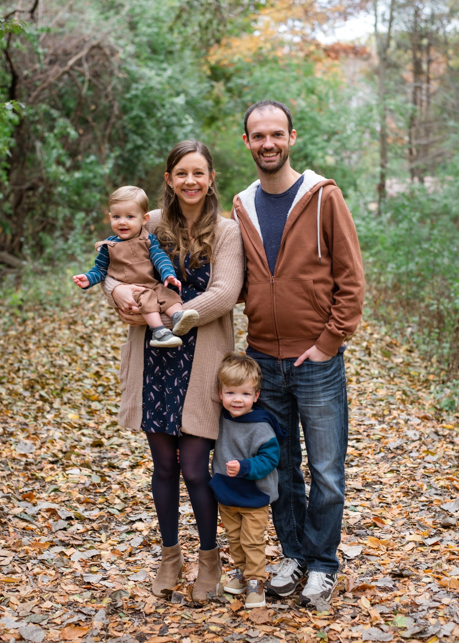 Parent and baby share joyful moments together during outdoor autumn family photo session.