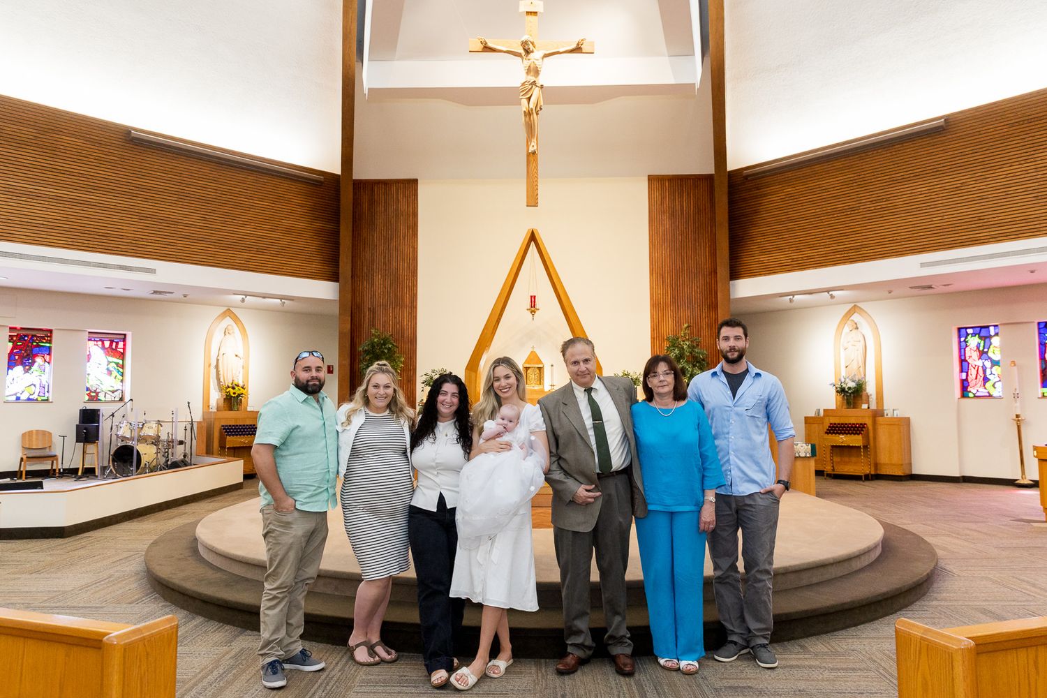 Interior of a church wedding ceremony with natural light streaming through modern windows and wooden pews.