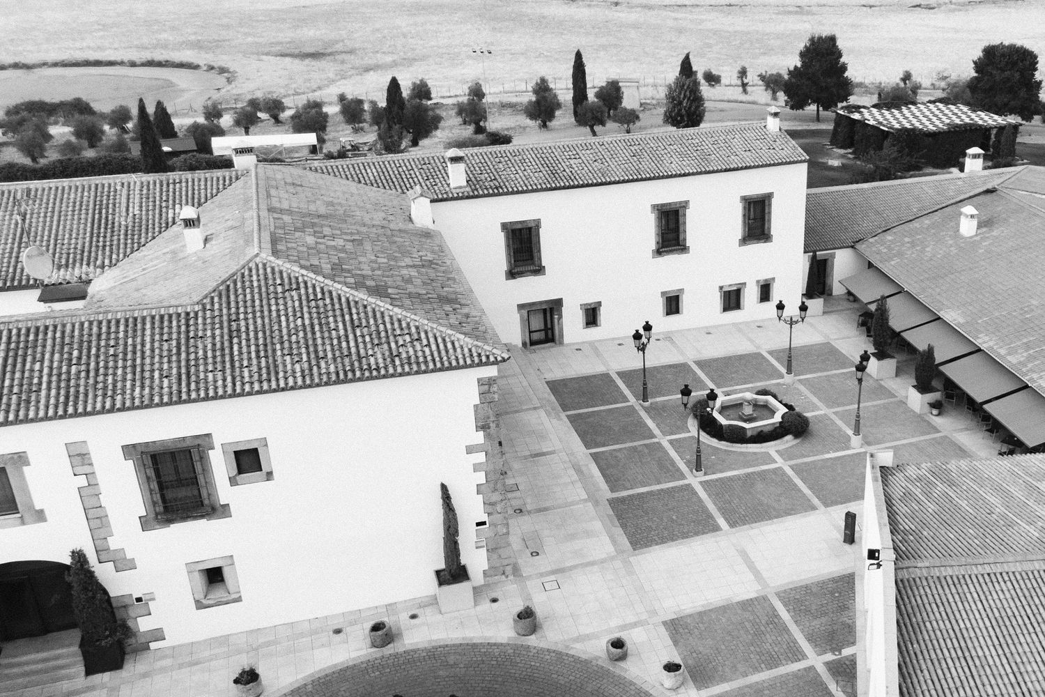 Aerial black and white cityscape view showing white buildings with red tiled roofs in Portugal's historic architecture.