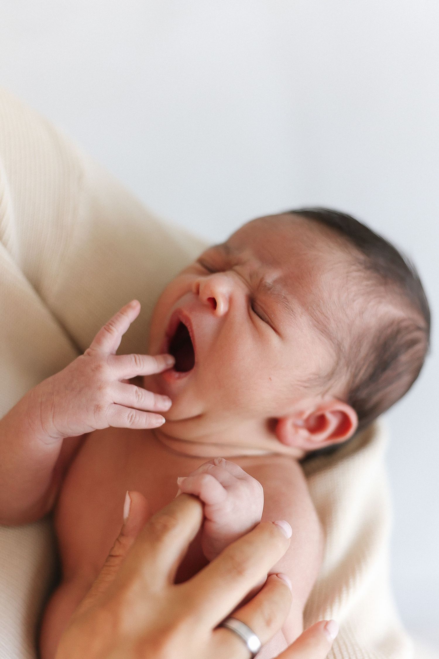 Close-up view of gentle massage techniques being performed on a baby's head and face area.