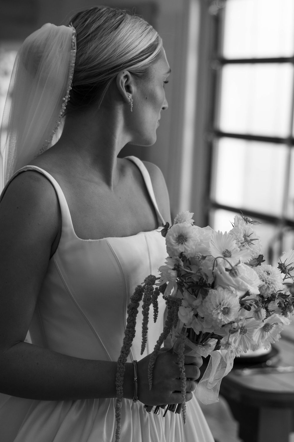 Black and white bridal portraits with classic bouquet in natural window light.