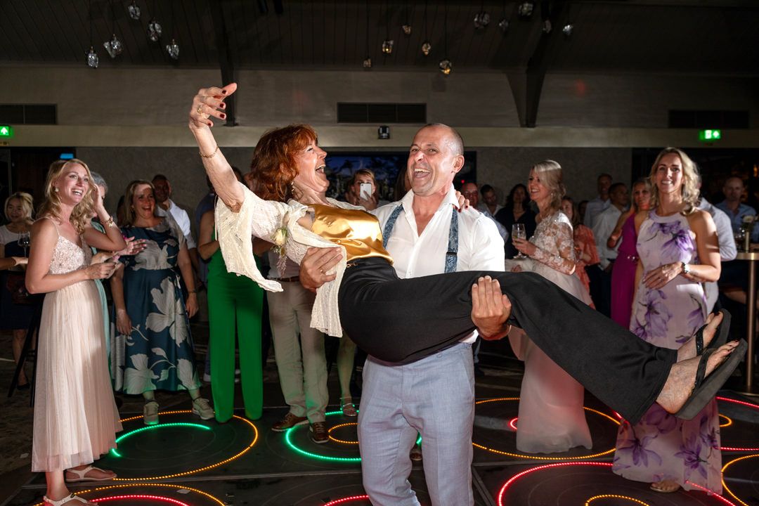 Bruidegom danst met zijn moeder op de dansvloer tijdens het trouwfeest