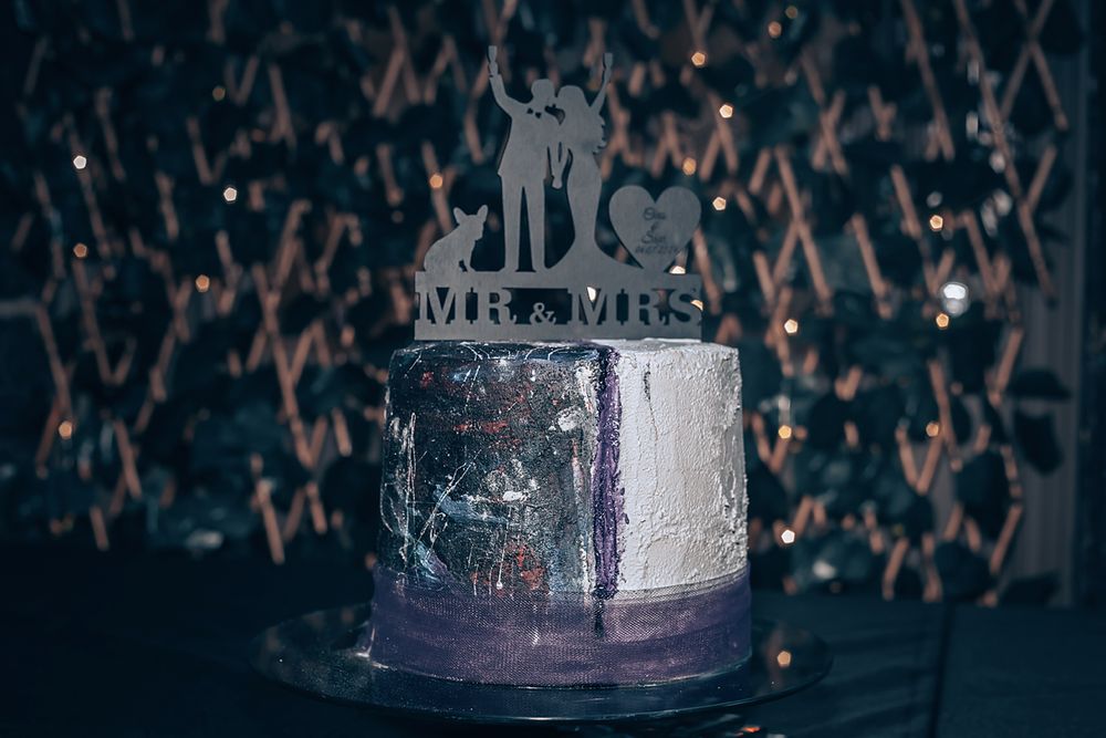 Dark moody glass jar illuminated by sparkly light against textured metallic background.