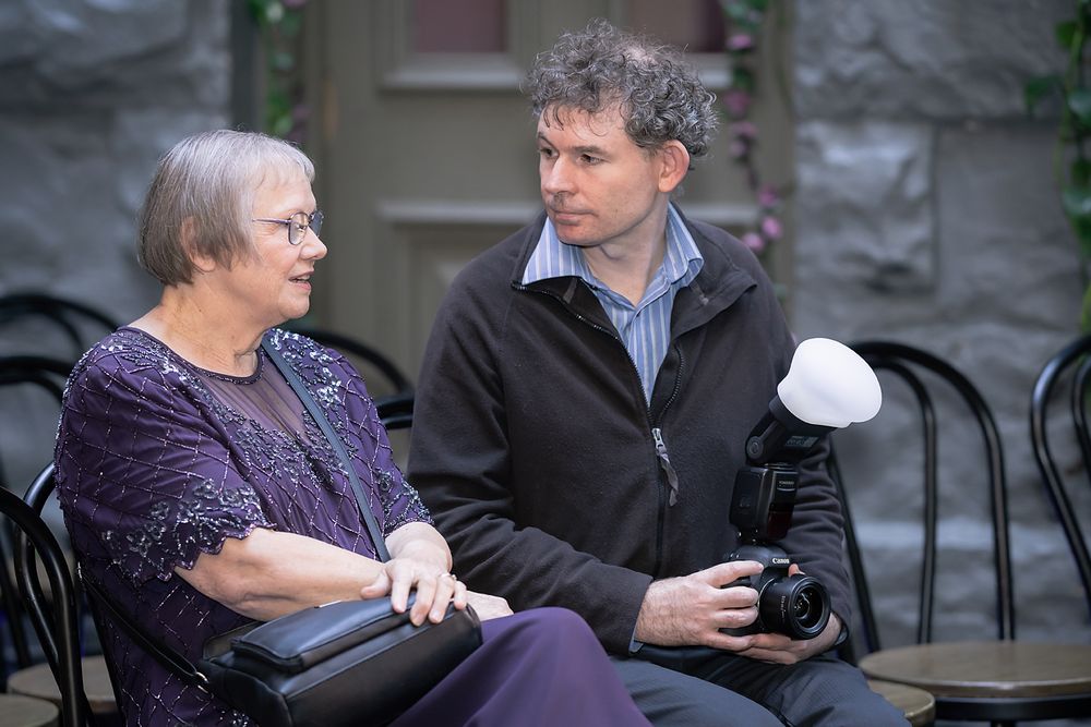 People sitting on an outdoor patio engaging in casual conversation.
