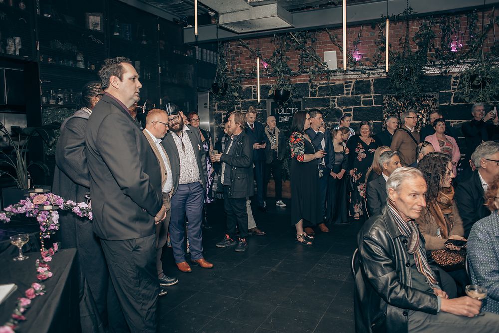 People enjoying a crowded nightclub event with dark lighting and festive atmosphere.