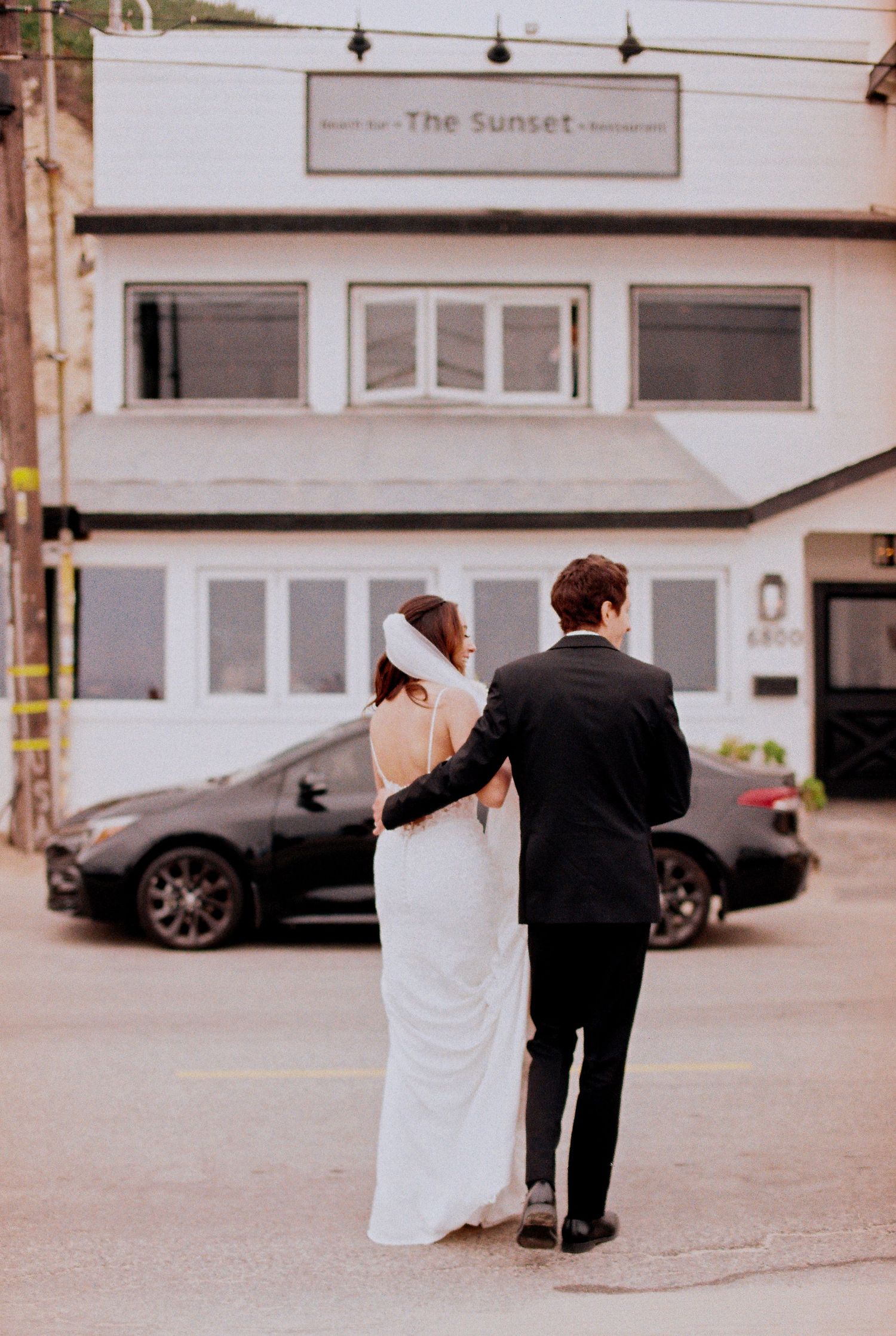 35mm film photo of the bride and groom walking toward The Sunset Restaurant in Malibu.
