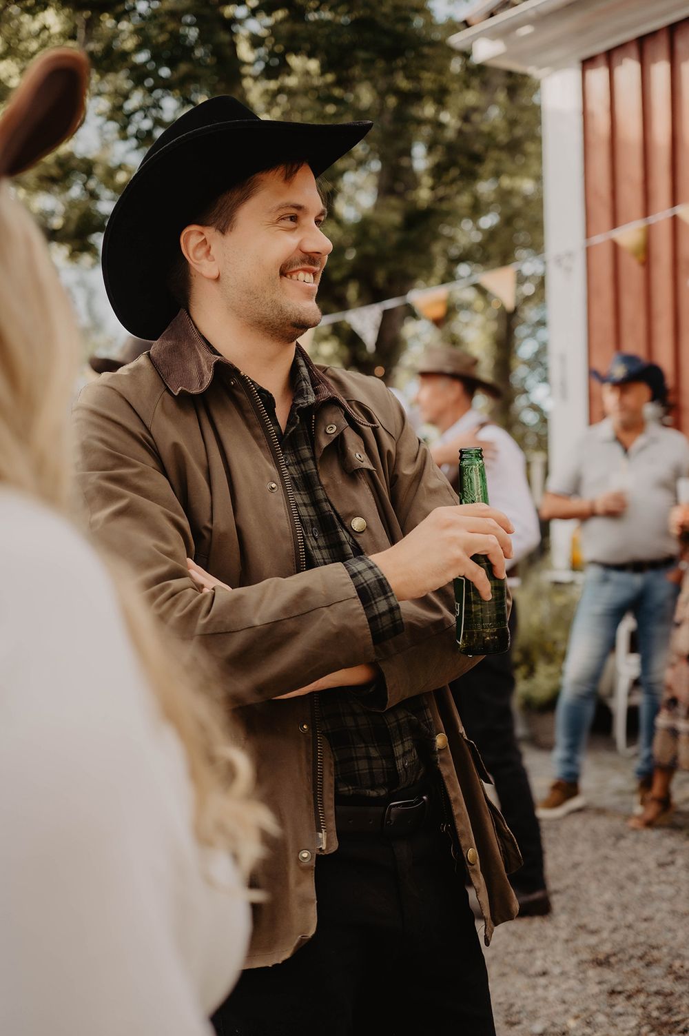 En man i cowboyhatt dricker öl på cowboyfest, event foto av Lets Bloom Media