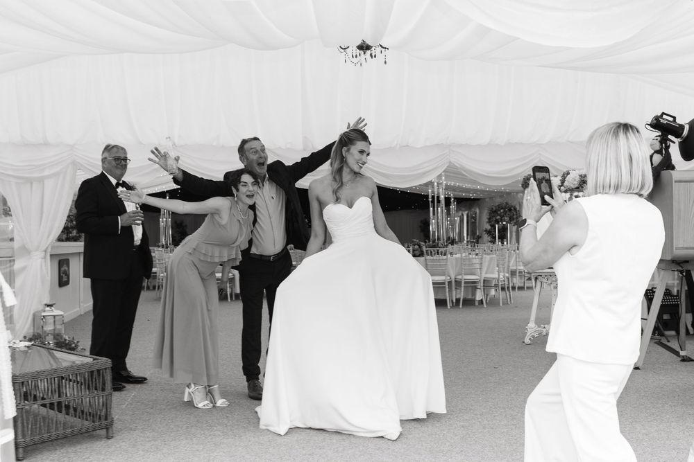A series of black and white wedding moments with couples dancing and celebrating at reception under white tents.