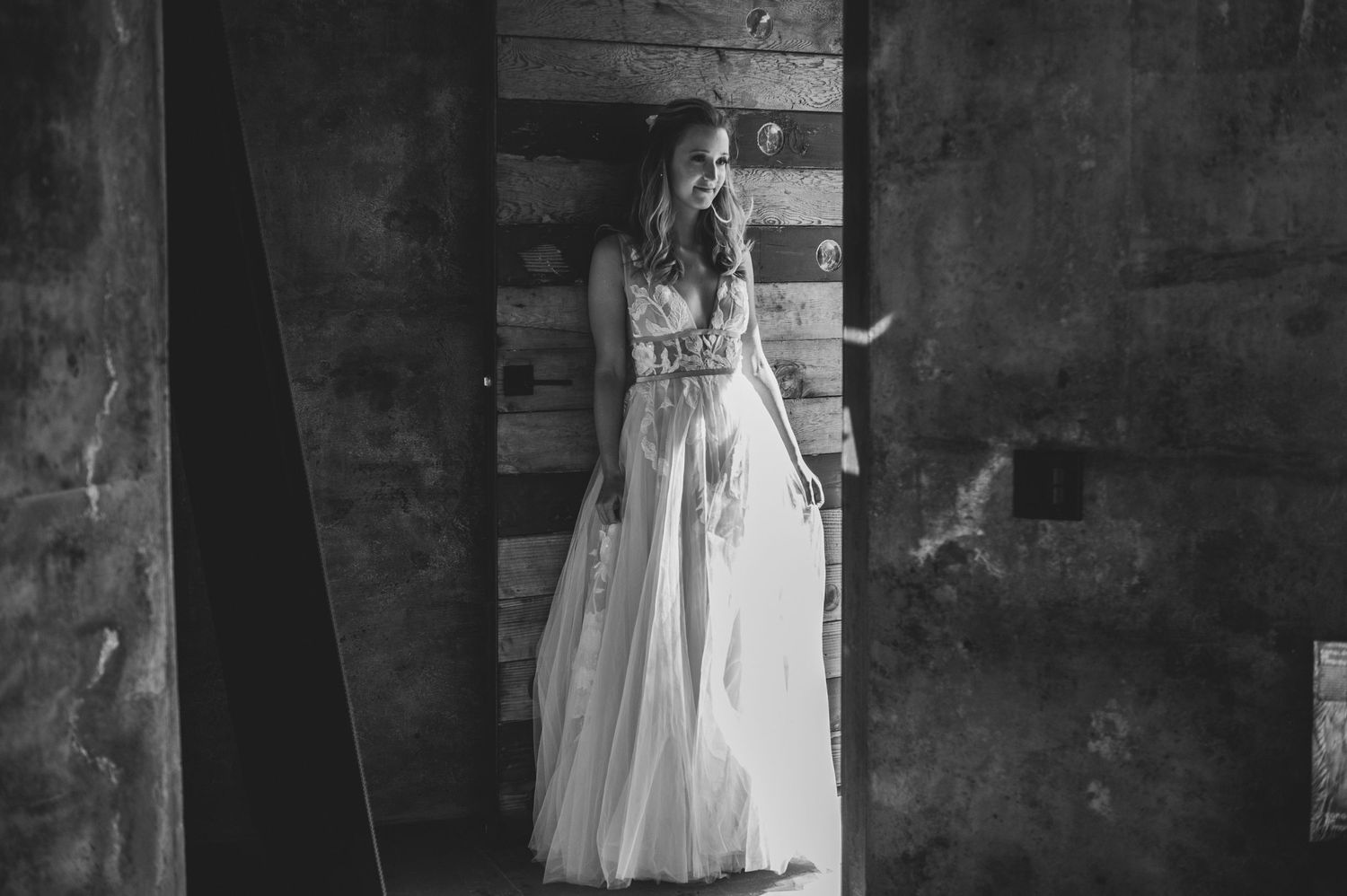 Black and white bridal portrait series showing a delicate lace dress and natural bouquet in classic studio lighting.