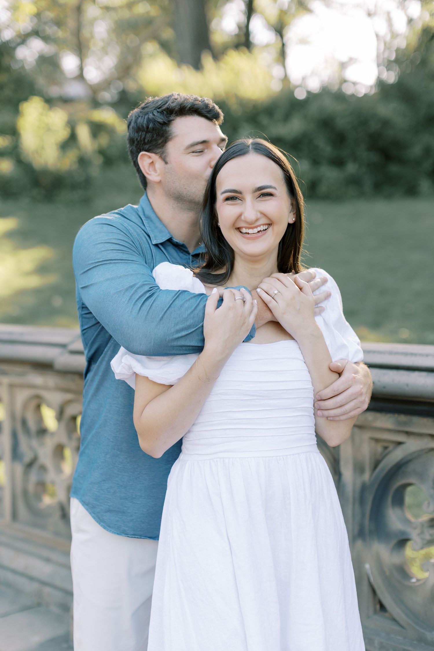 A couple enjoys an intimate candid moment together in an outdoor setting during a photo session.