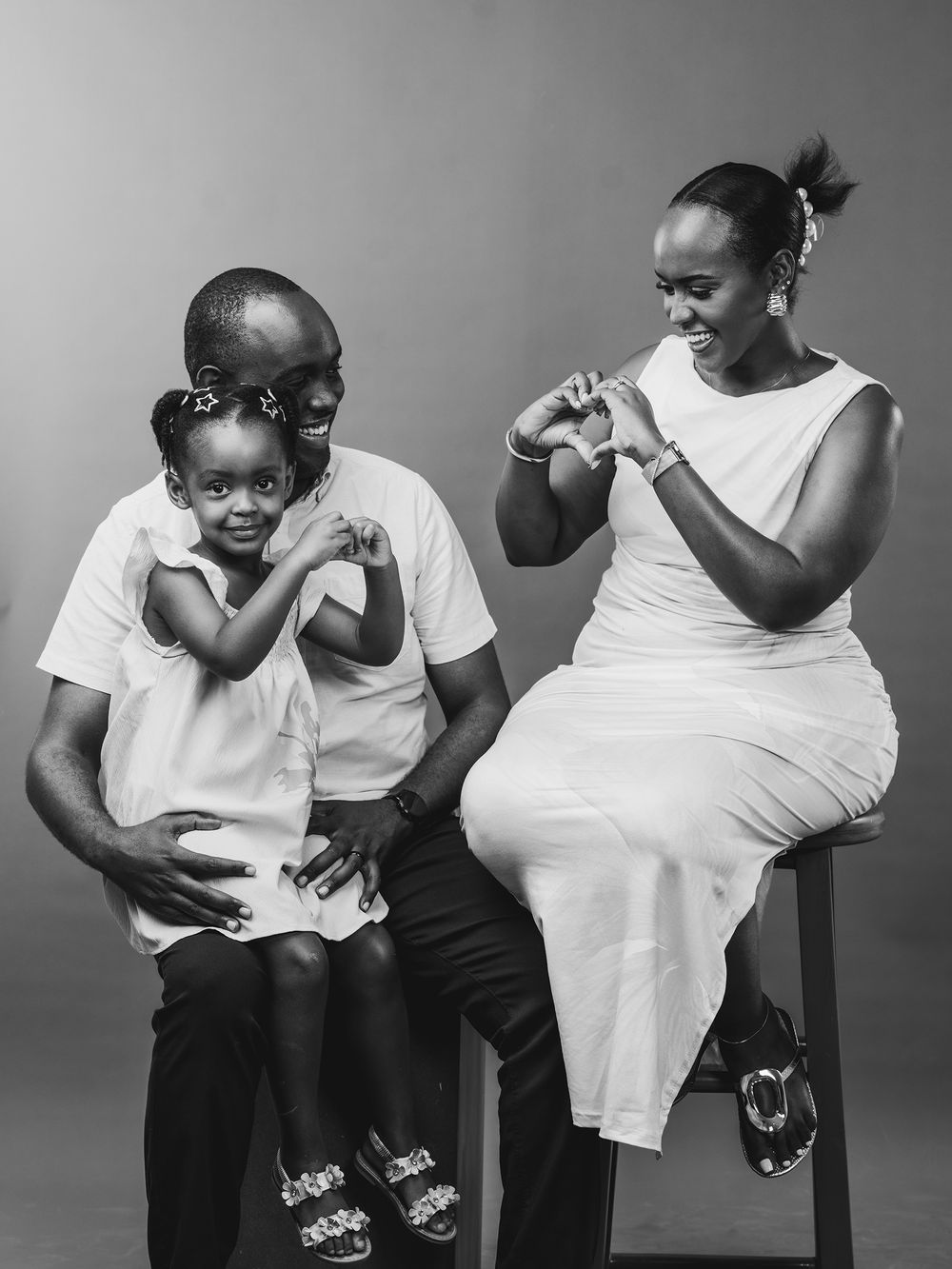 A minimalist black and white photo series showing tender moments between parent and child in matching white shirts.