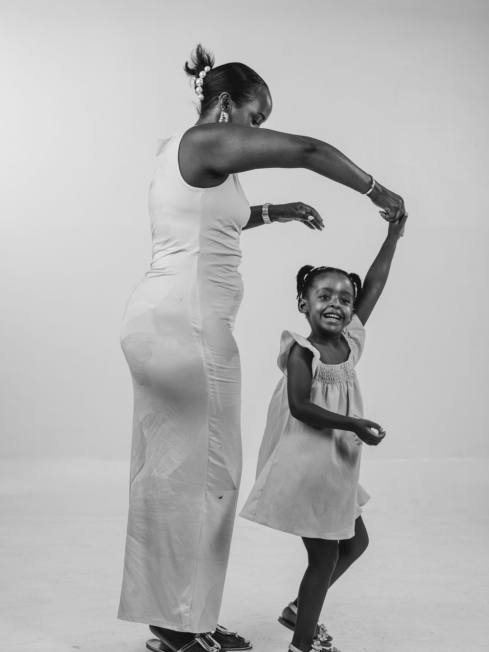 A sequence of black and white photos shows a couple dancing together in graceful movements while wearing white clothing.