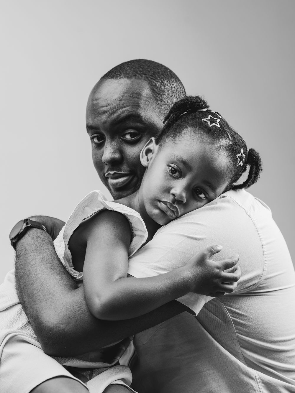A series of black and white photographs showing tender embraces and intimate family moments.