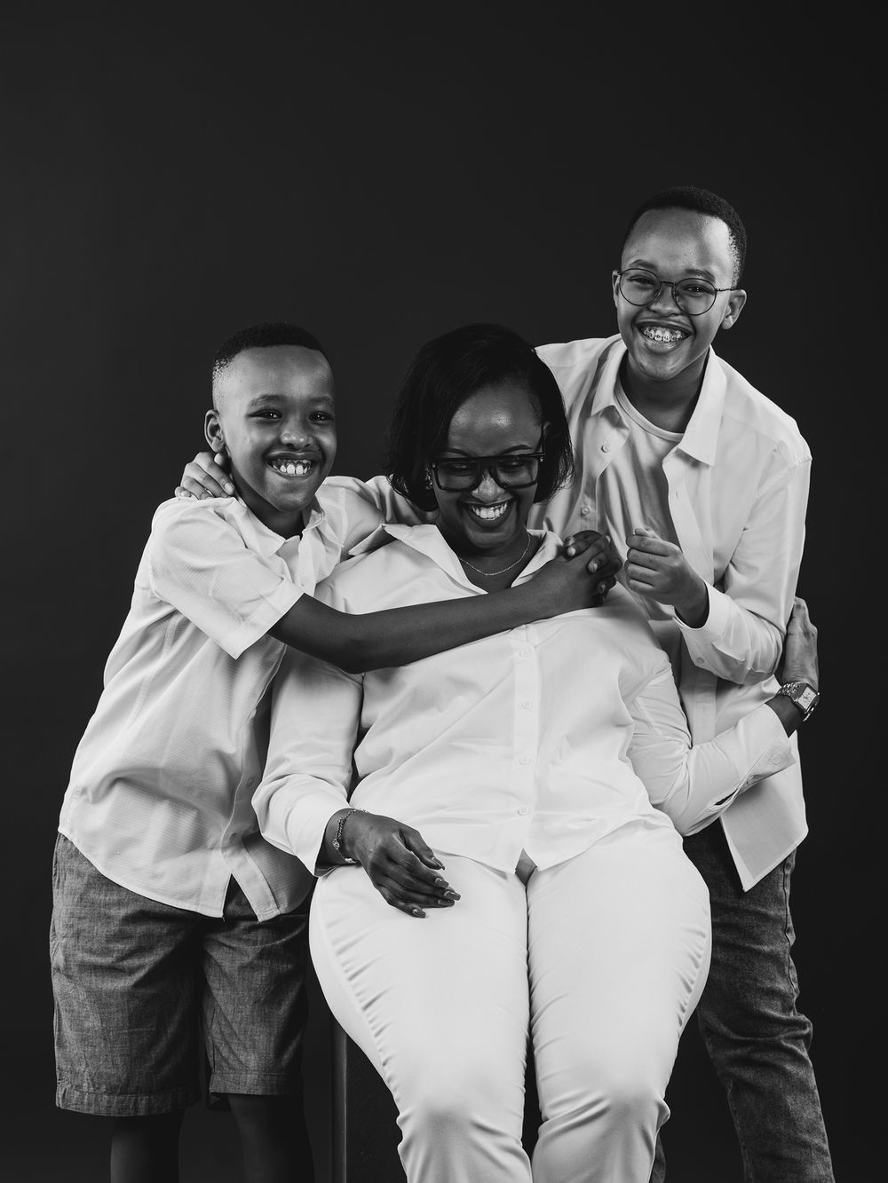 A black and white photo series showing two people in white shirts sharing joyful laughter and embraces.