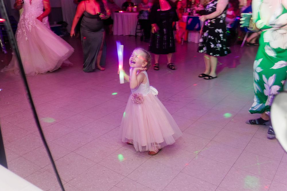 Wedding reception dance party with pink and purple lighting creating a festive atmosphere on the dance floor.