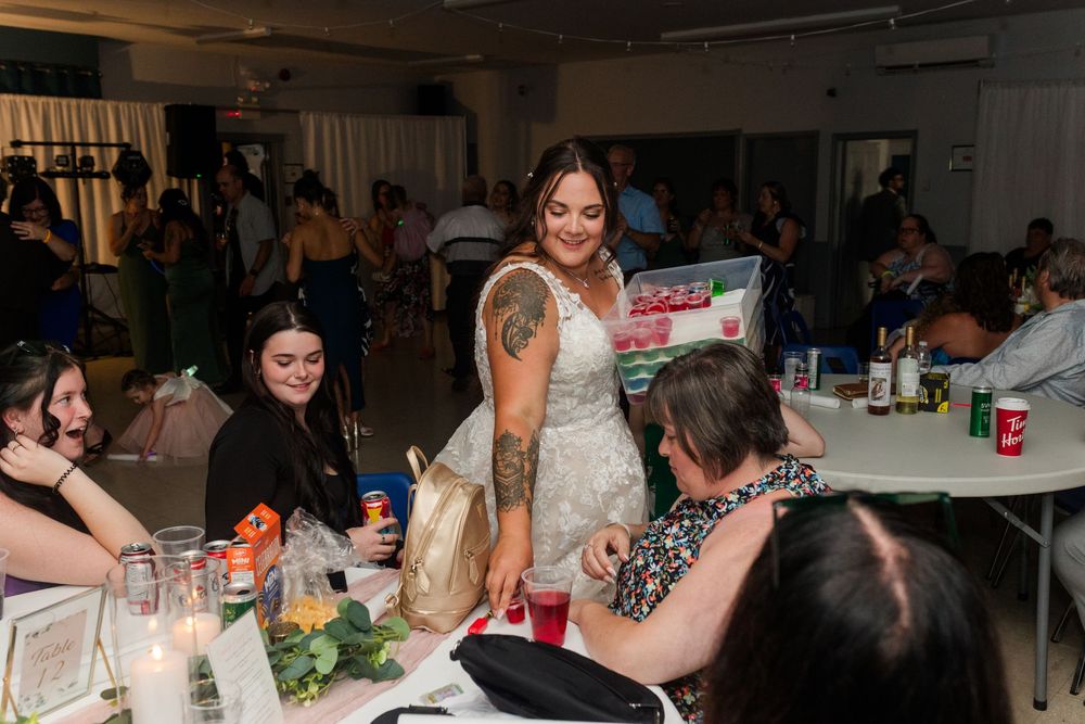 Guests enjoying conversations and refreshments at tables during an indoor social gathering.