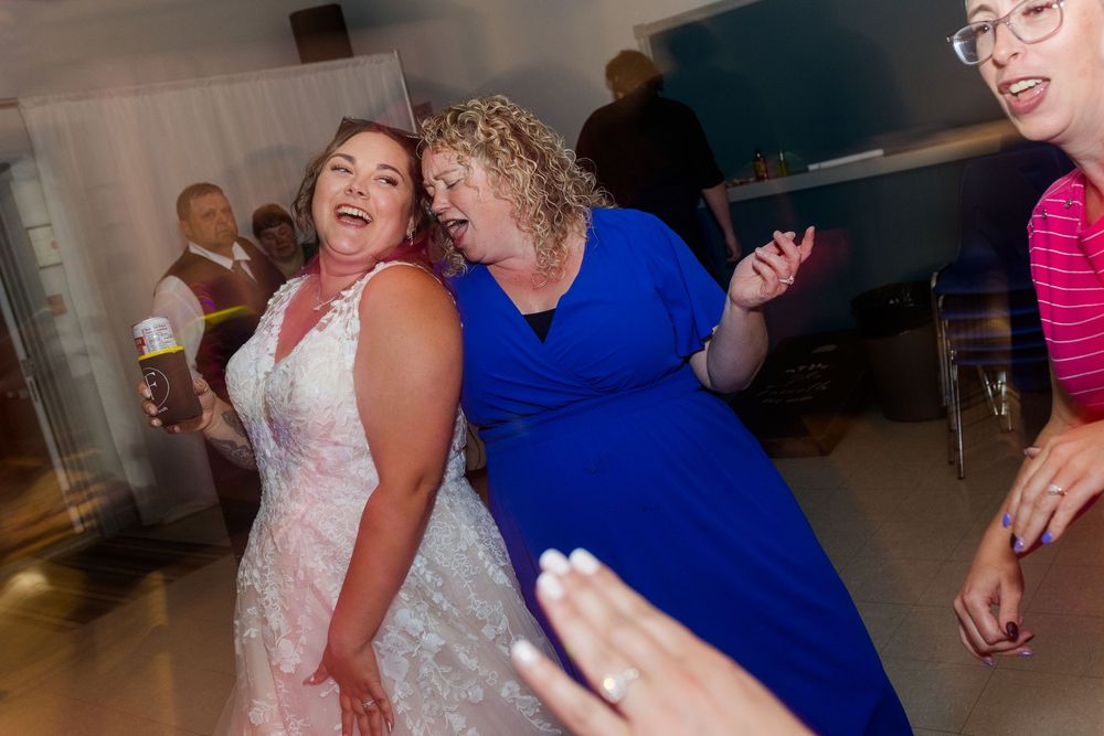 Wedding guests enjoying themselves while dancing at an indoor reception venue.