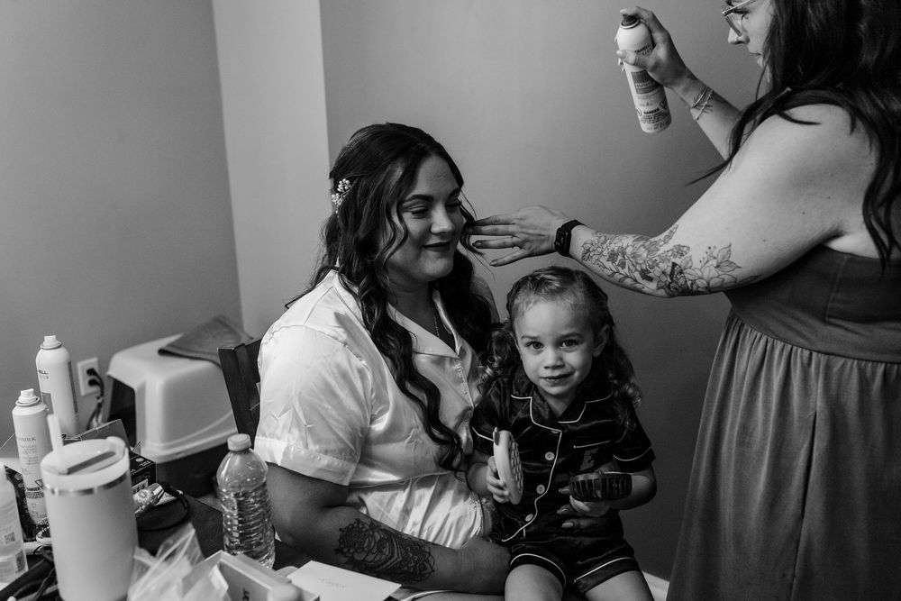Emotional black and white wedding scene showing intimate moments between loved ones getting ready for the ceremony.