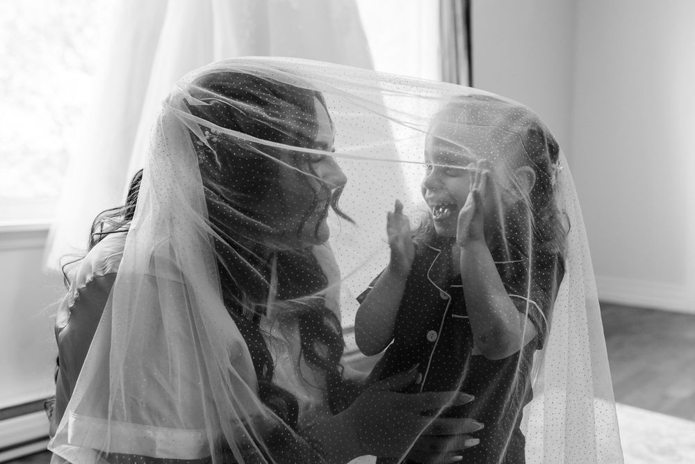 A black and white sequence showing silhouettes of people hugging and embracing by a window.