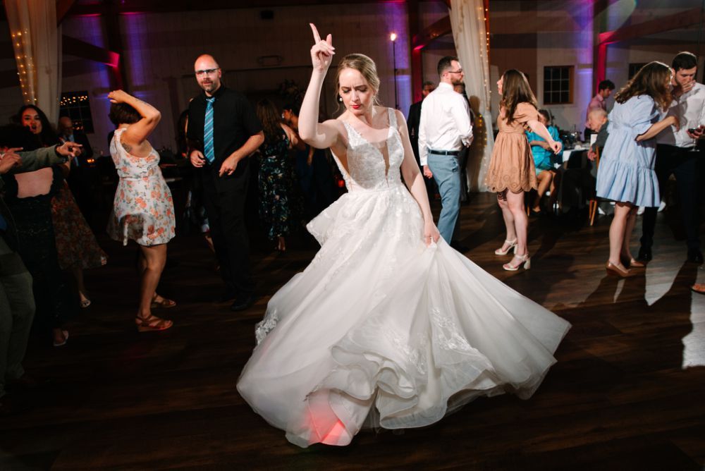 Wedding reception dance party showing guests dancing and celebrating on a dimly lit dance floor.