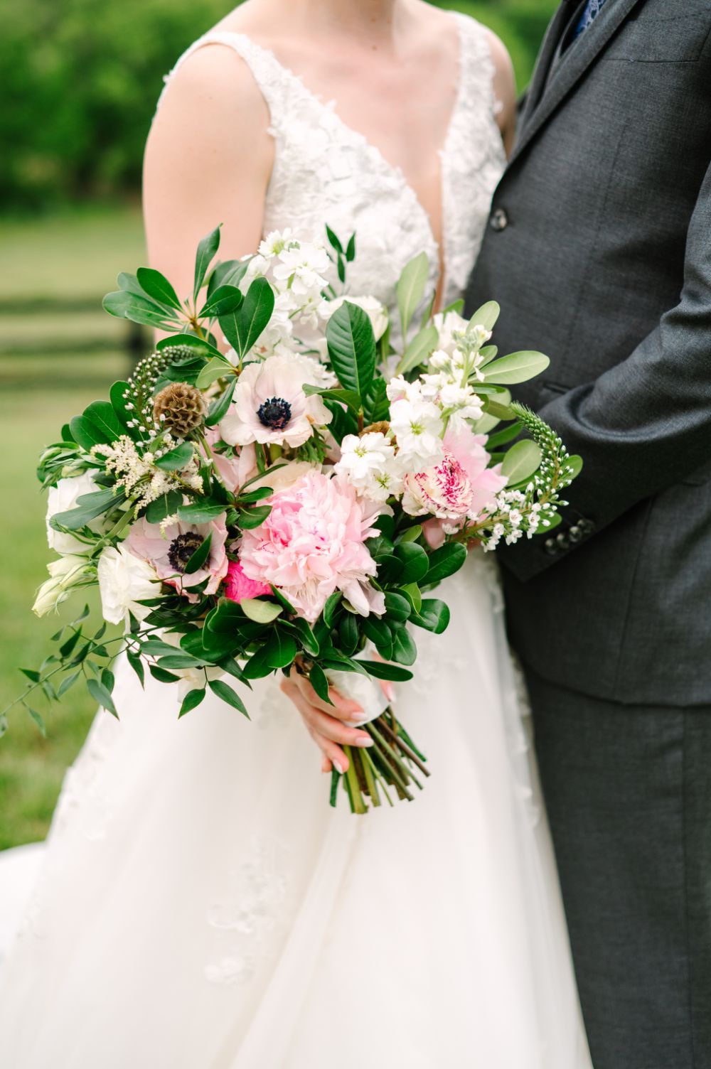 Beautiful bridal bouquet featuring pink peonies, white anemones, and fresh greenery.