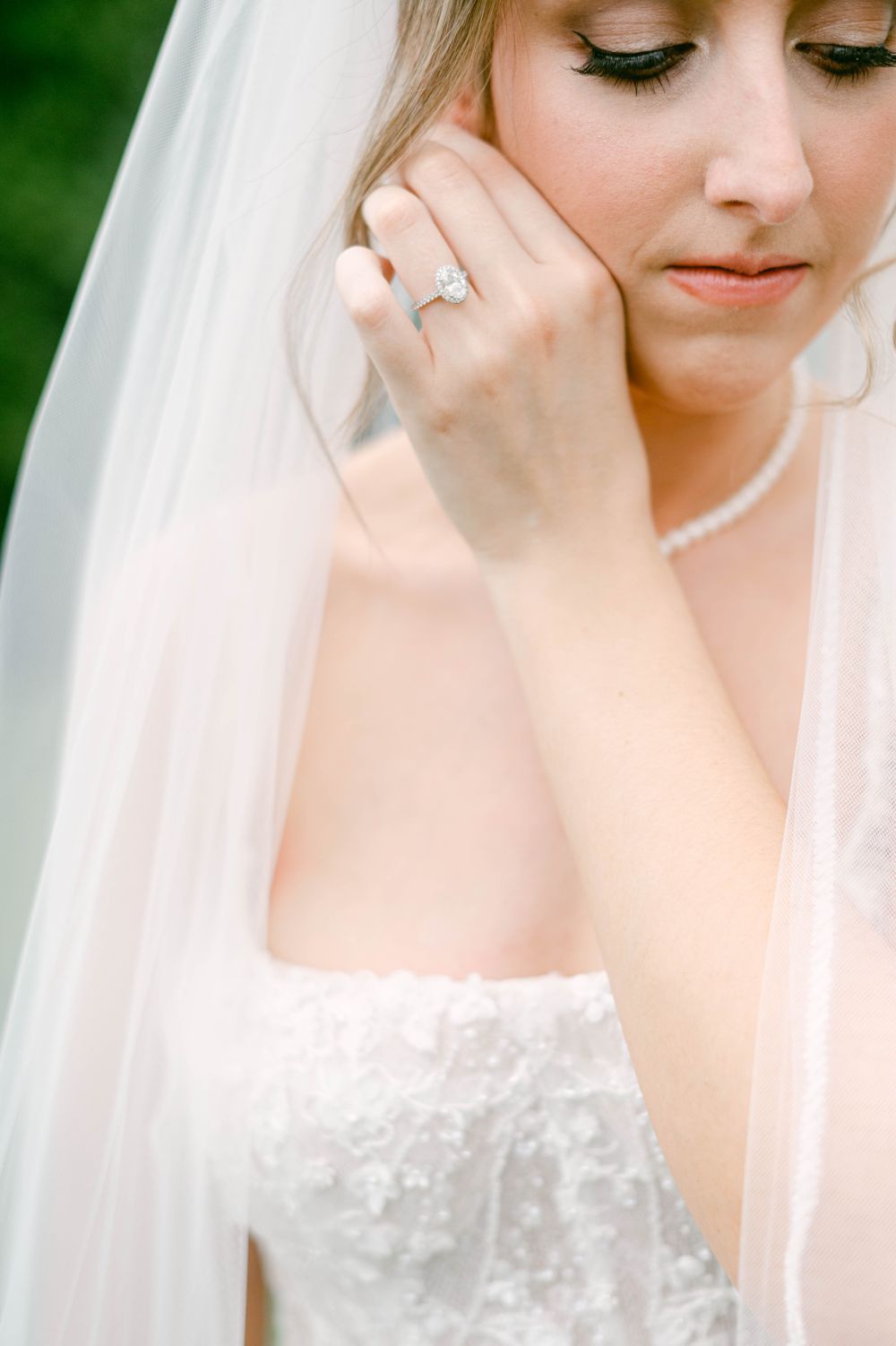 Close up of a delicate lace wedding gown and veil with jewelry details.