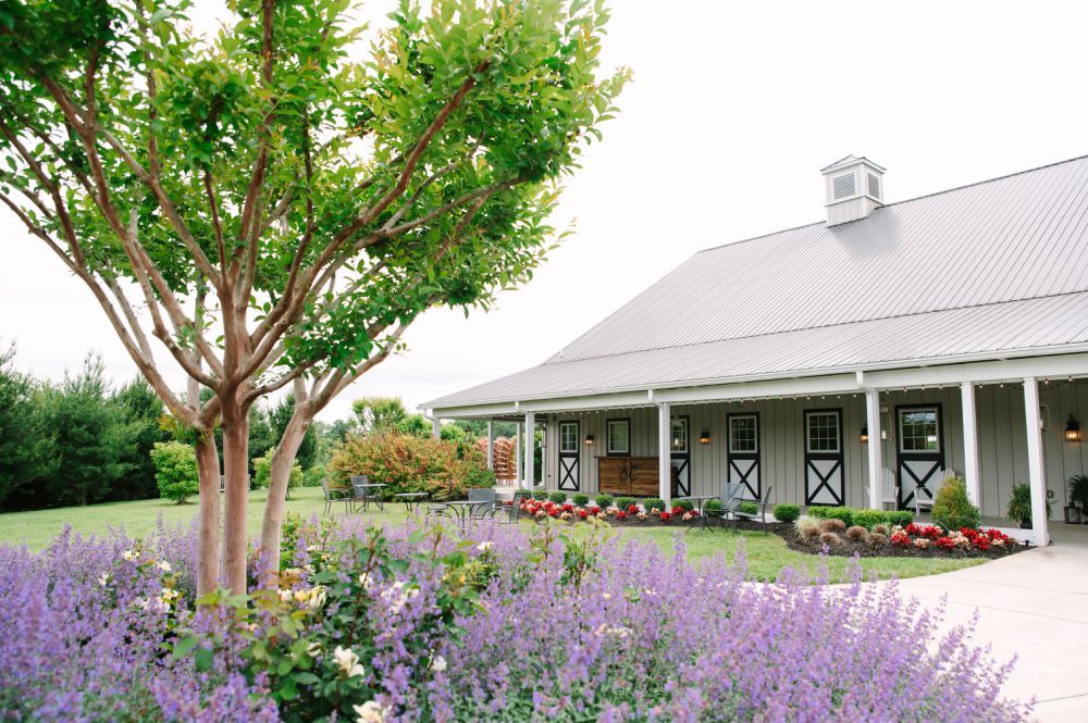 Rustic barn venue with beautiful purple lavender garden and white trim exterior.