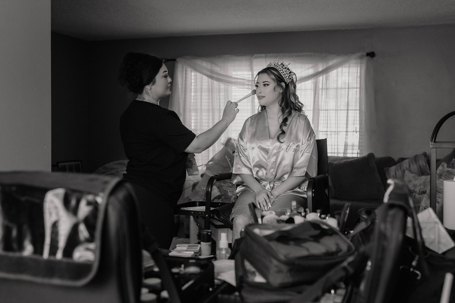 Getting ready scene in black and white showing preparations in a room with window light.