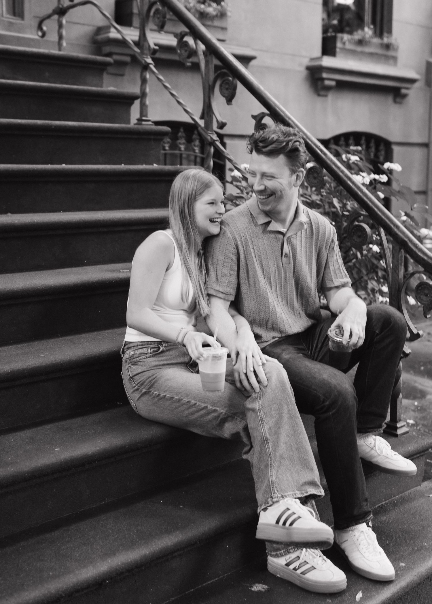 A couple sits intimately on concrete steps in a series of black and white photos showing progressive moments.