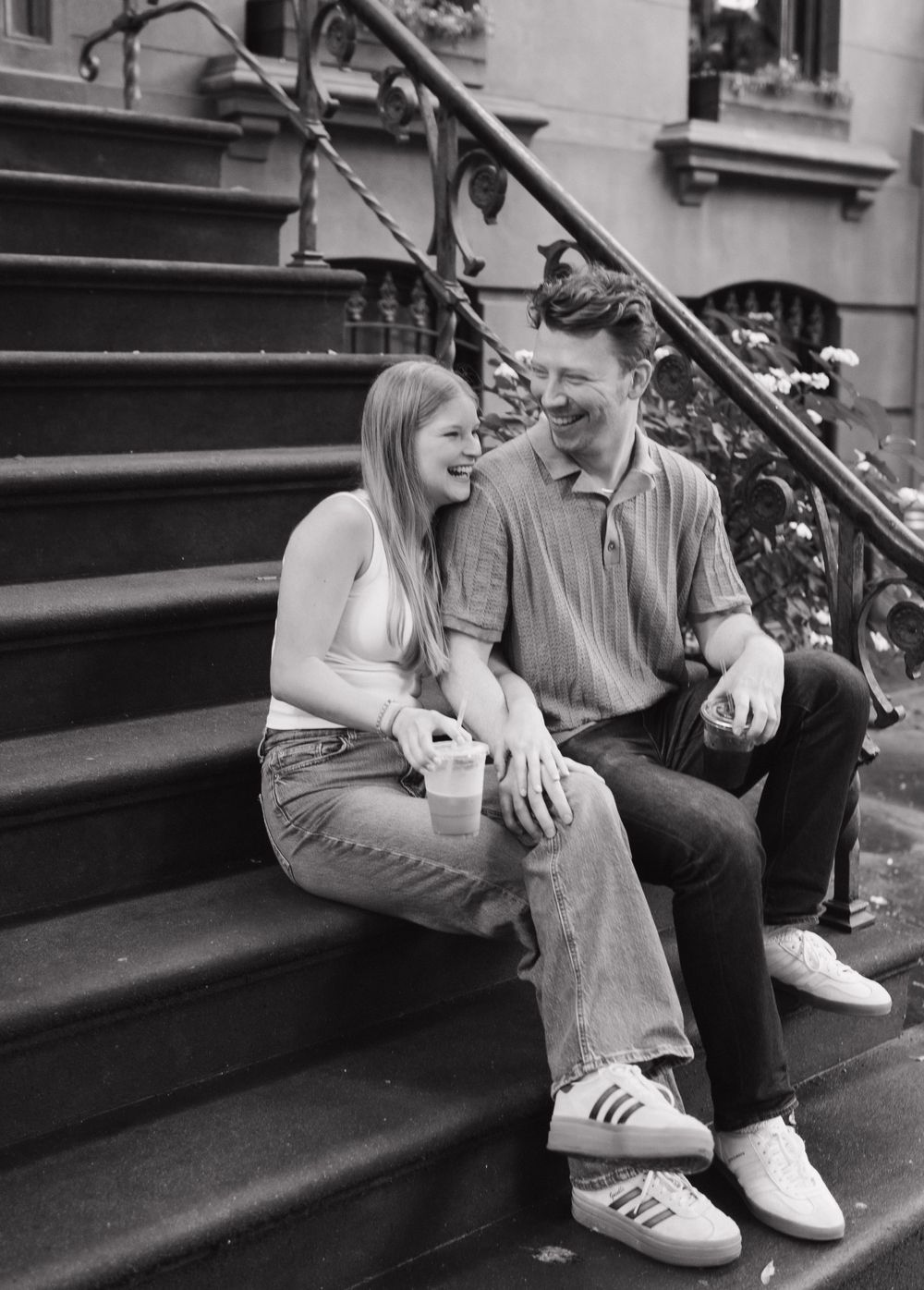 A couple sits intimately on concrete steps in a series of black and white photos showing progressive moments.