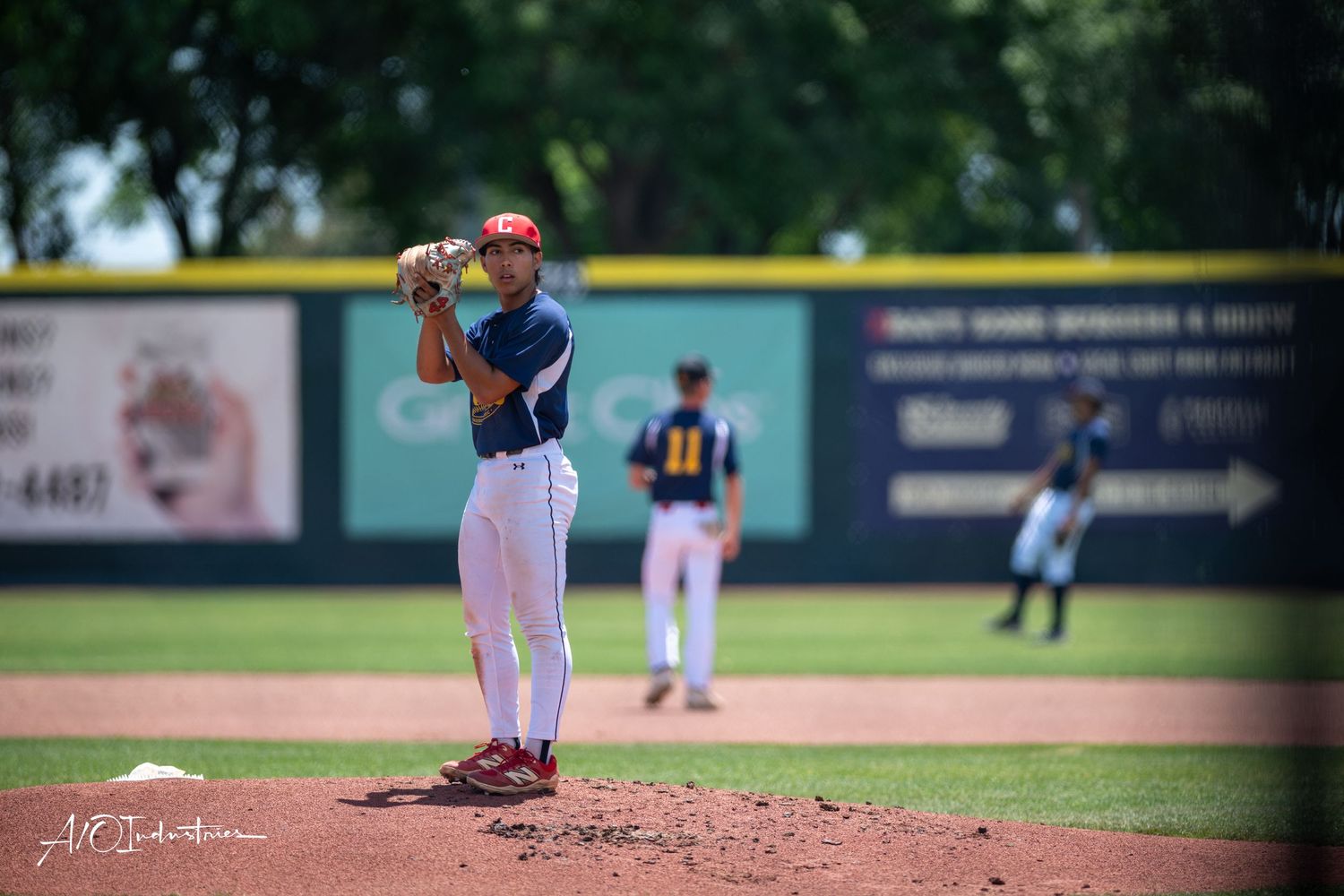 Baseball pitcher in mid-delivery motion throwing from the mound during a game at an outdoor stadium.