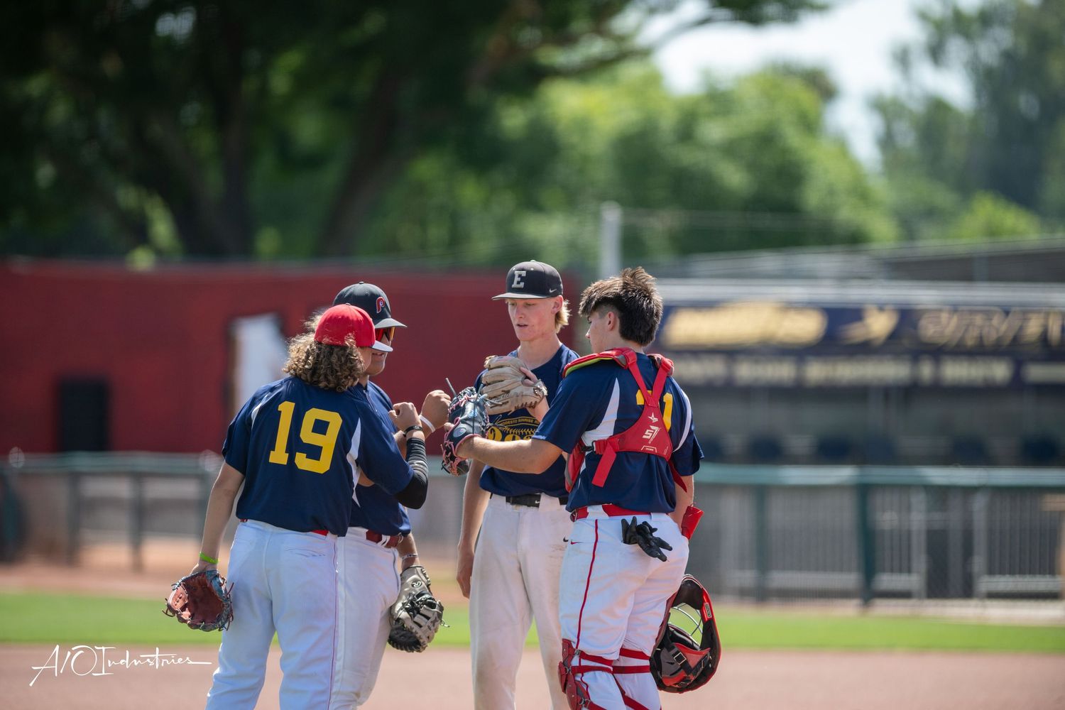 Baseball players compete during an intense game with fielding and batting action on a sunny day.