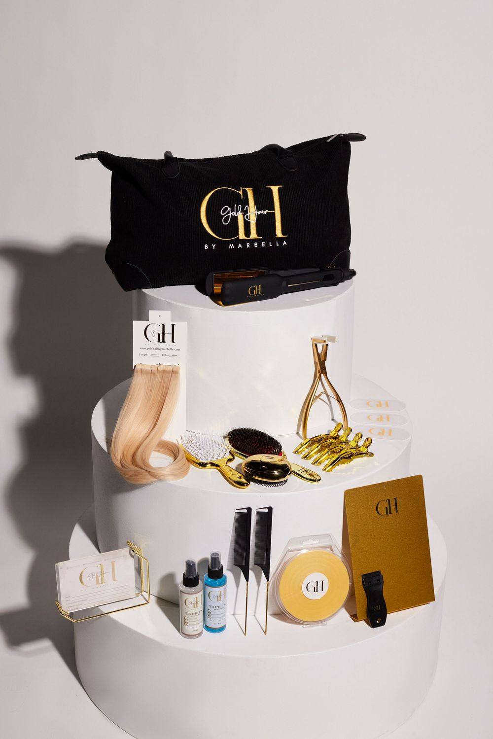 Beauty product flatlay featuring GH brand cosmetics and accessories on white background.