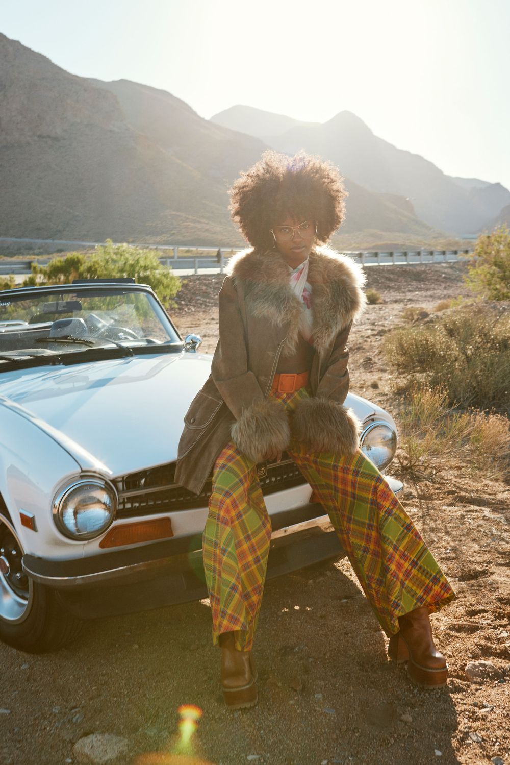Vintage car photoshoot in desert landscape during golden hour.