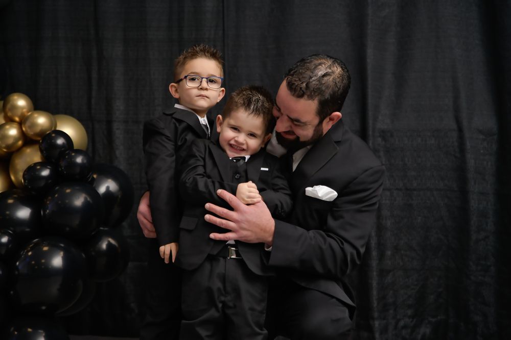 Black and white sequence showing tender moments between father and son in formal wear.