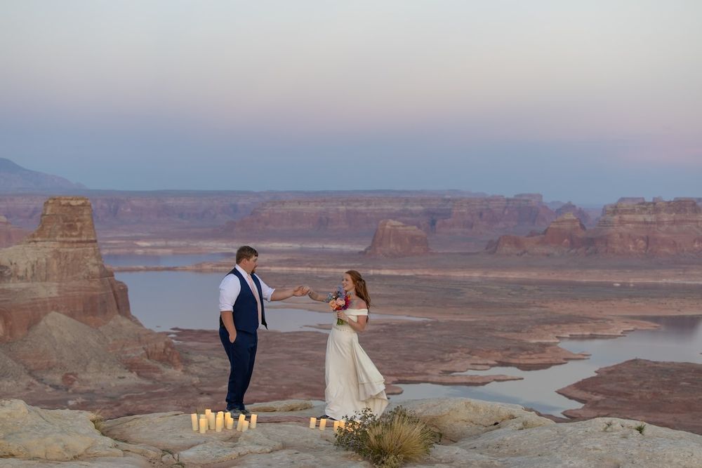 Utah desert engagement photos with scenic canyon views overlooking Lake Powell and towering red rock formations at sunset.