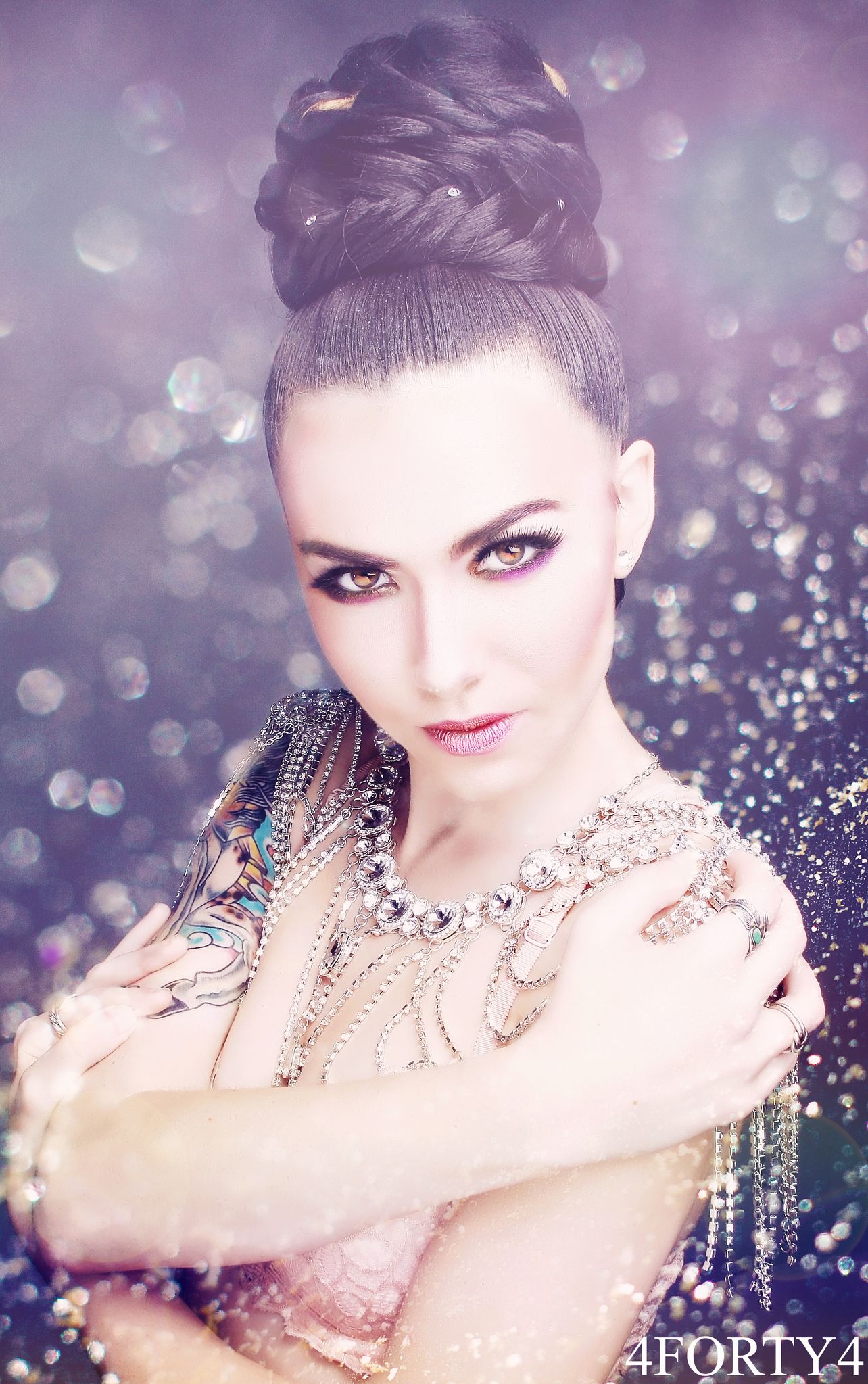 Glamour portrait with sparkling jewelry diamonds and dramatic makeup against purple background.