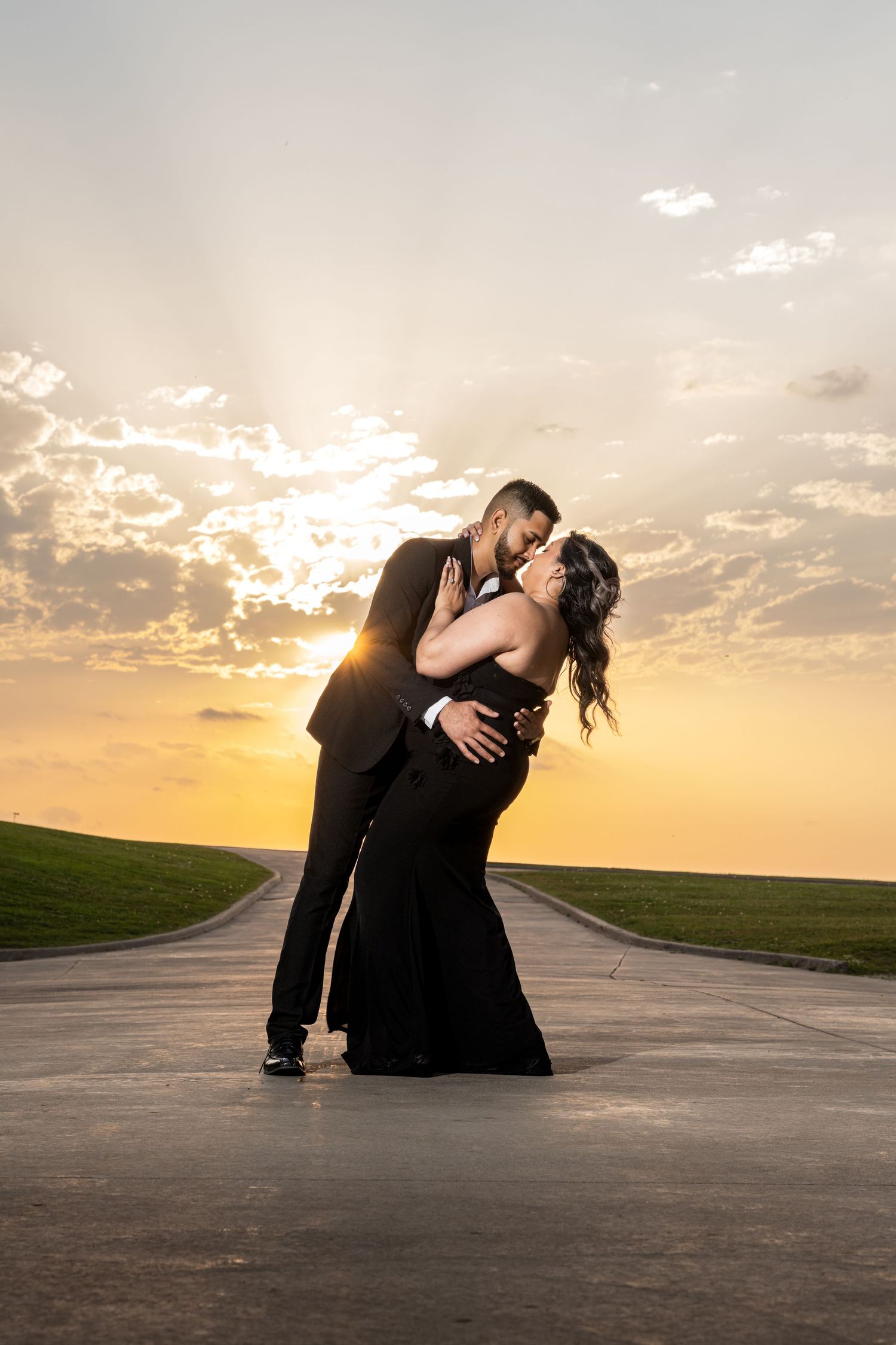 Dramatic sunset silhouette dance pose on an empty road against golden sky.