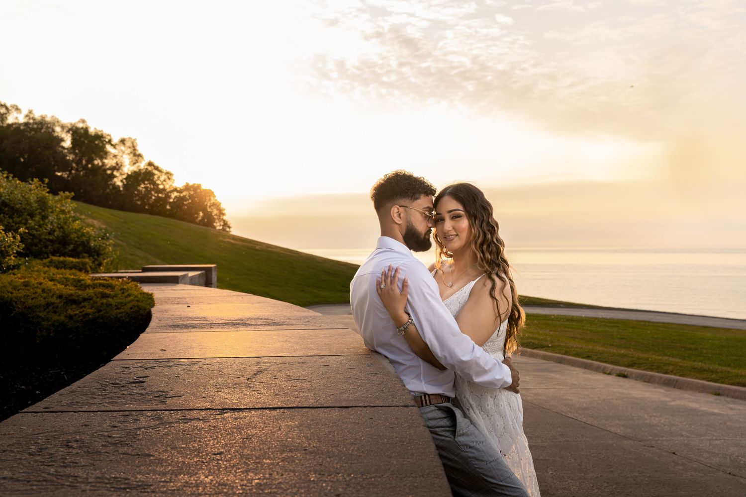 Romantic sunset photo shoot with elegant couple on an empty road showing tender moments.