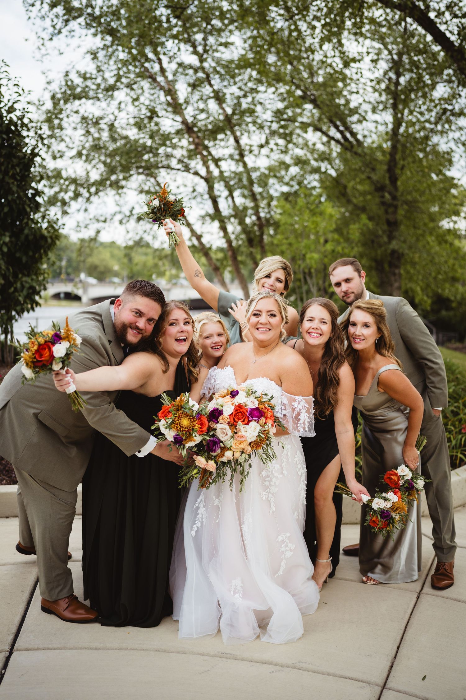 Wedding party poses together in a fun progression of candid group photos with autumnal floral bouquets.