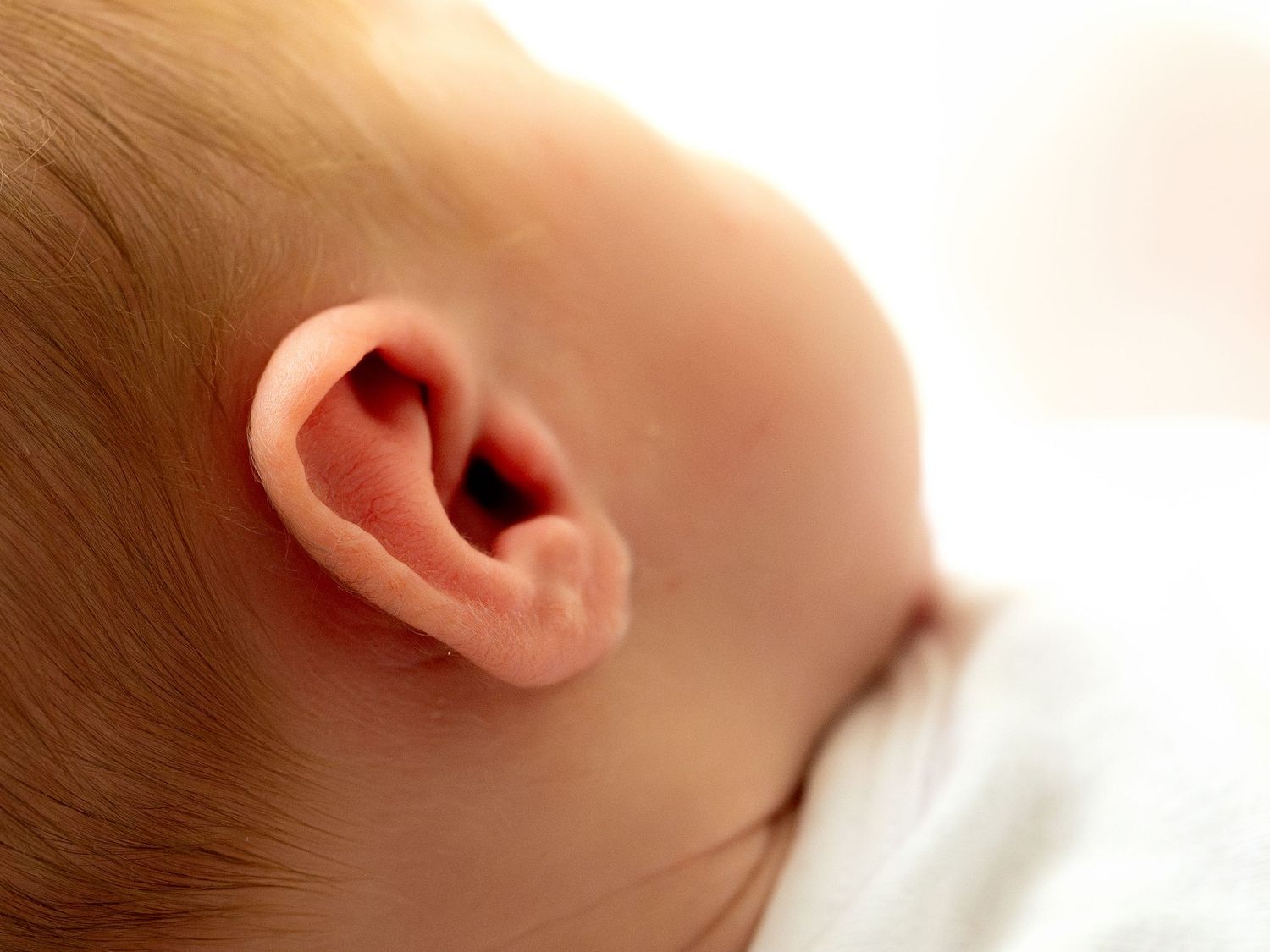 Close-up photo of a human ear showing the outer ear anatomy and skin detail.